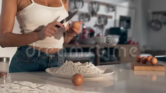 女人在厨房做饭女人把鸡蛋打碎成面团做面团面包和面包视频的预览图