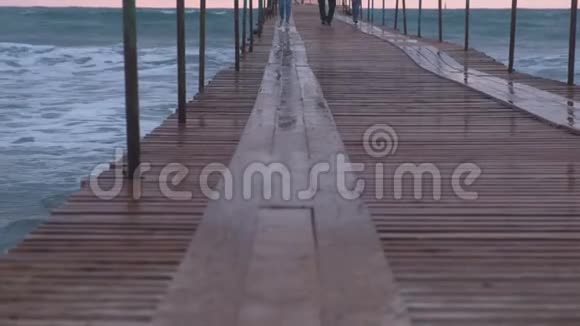 一家人在暴风雨中从海上码头的海浪中奔跑波浪在海上的木墩上飞溅美丽美丽视频的预览图