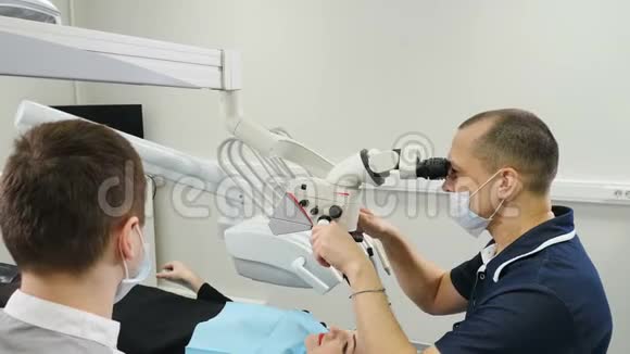 医生用显微镜现代牙科诊所的牙医治疗病人正畸医生与一名助手合作这就是视频的预览图