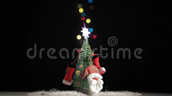 特写镜头圣诞树和圣诞老人在黑色背景的桌子上旋转视频的预览图