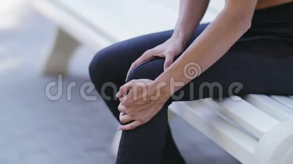 接近女运动员跑步者在疼痛中触摸膝盖健身妇女在夏季公园跑步视频的预览图