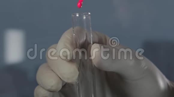 男性戴手套的手拿着试管或带有透明液体的玻璃器皿视频的预览图