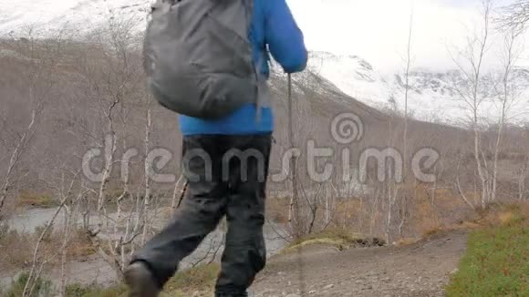 一个中年男人带着背包旅行一条山路他停下来看着山顶继续往前走视频的预览图