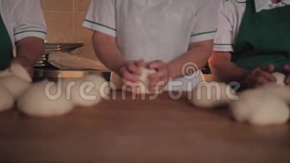 厨房里的女人为烤糖果准备面团他们互相传递视频的预览图