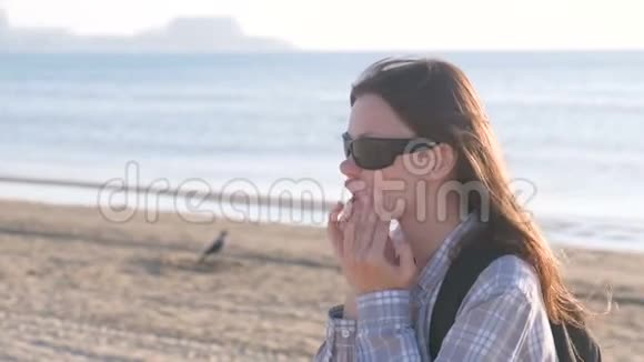 在海滩上做面部按摩的女人侧视视频的预览图
