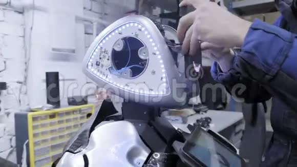 生产机器人的工厂科学家把板子插入机器人的表面给机器人带来生命视频的预览图