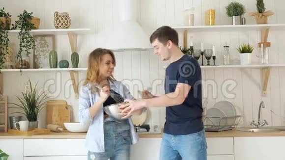 年轻的女人在厨房里用碗搅拌食物视频的预览图