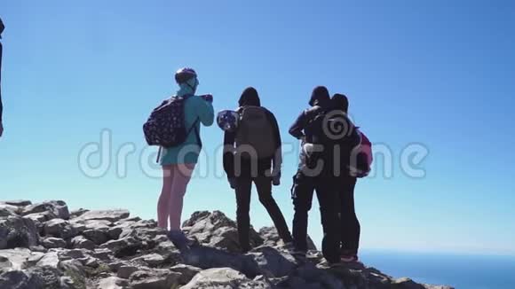 游客们登上山顶眺望下面的大海欣赏后面的景色视频的预览图