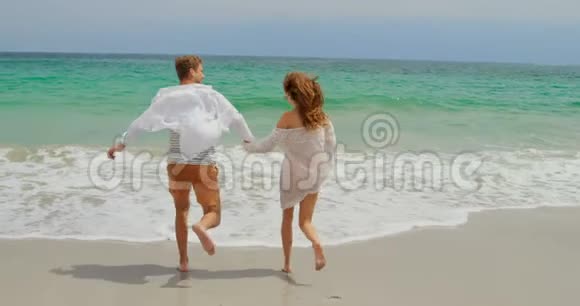 高加索夫妇在海滩上奔跑的后景视频的预览图