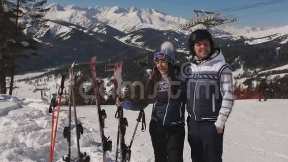 一对年轻的滑雪者在山顶上欣赏风景聊天视频的预览图