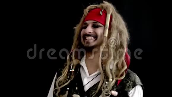 快乐的穿着奇装异服的男人海盗在黑色的背景下微笑视频的预览图