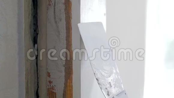 房屋装修时用抹子将旧墙面腻子找平的特写慢镜头视频视频的预览图
