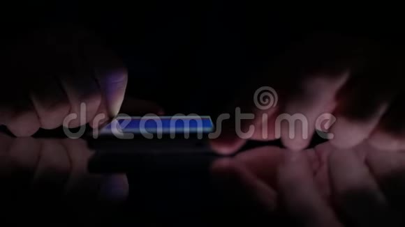 男子在黑暗中浏览智能手机网页视频的预览图