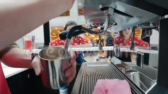 咖啡师在咖啡机里搅拌牛奶顾客看着它视频的预览图