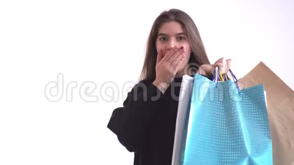 美丽的女孩微笑着拿着购物袋惊讶不已零售连锁店库存视频的预览图
