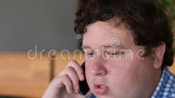 一个疲惫的年轻人在室内打电话视频的预览图