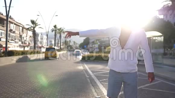 在城市中心的一个年轻人骑着出租车或一辆路过的汽车背光视频的预览图