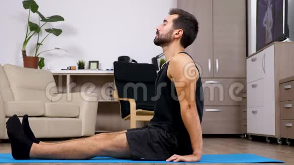 男人在蓝色垫子上放松不同的瑜伽姿势视频的预览图