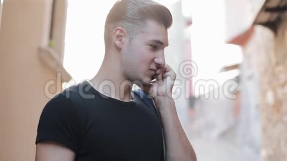 年轻有魅力的男人在打电话站在老城里当一个游客回答他的问题时摄像机绕着他转视频的预览图