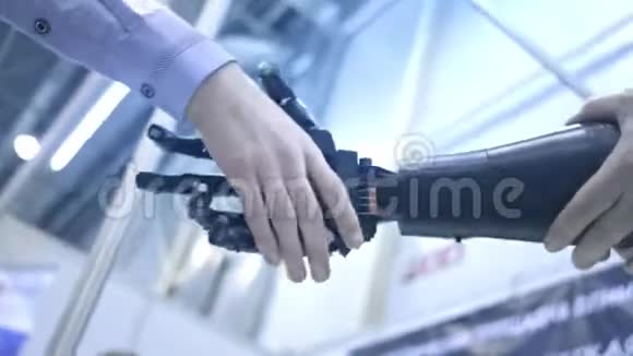 未来就是现在年轻学生科学家发明家的男性手摇动机器手臂一个男人和机器人握手视频的预览图