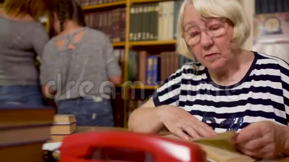 成年图书管理员坐在图书馆的一张桌子旁视频的预览图