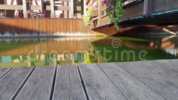 日落时分4k镜头在美丽的河岸和欧洲小镇的木桥下移动视频的预览图