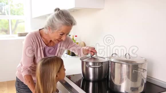 女孩高兴地和祖母一起做饭视频的预览图