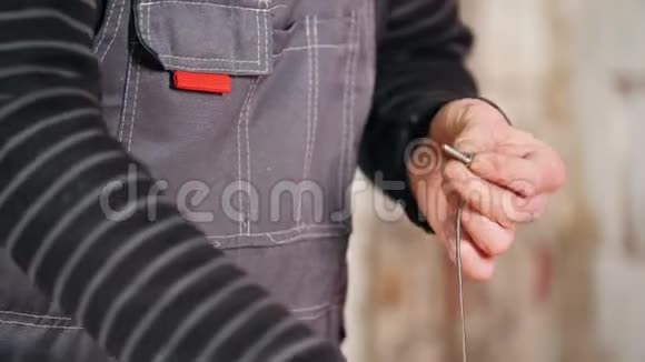 工业概念一个工人用铁丝把螺丝包起来视频的预览图