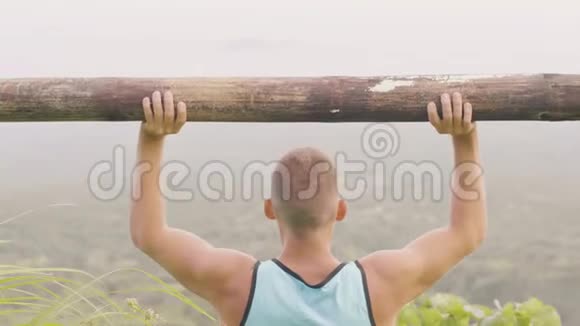 运动员在户外训练时用木杠铃举重健身者用重木材做压力运动视频的预览图