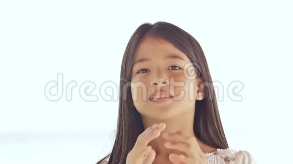 一个迷人的菲律宾女学生高兴地摆姿势旋转她的头发在夏日自然的白色背景上进行面部特写视频的预览图