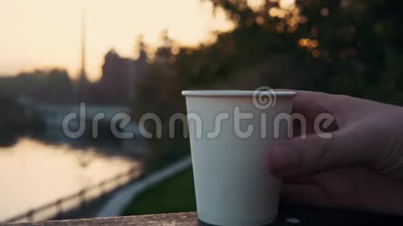 日落时分在水的背景下男人们着一杯热咖啡视频的预览图