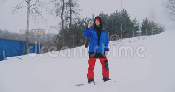 滑雪者在滑雪坡上驾驶时使用智能手机的慢速射击视频的预览图
