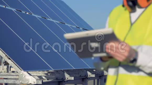 绿色能源概念关闭一个平板电脑在一个太阳能组件的建设者手中视频的预览图