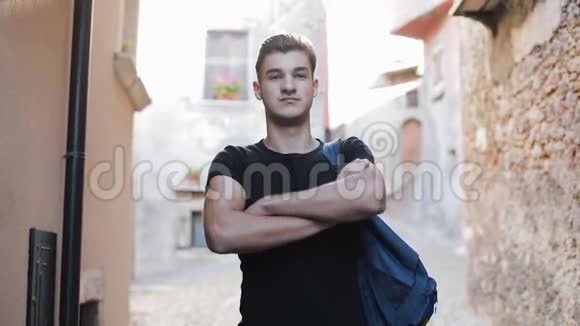欧洲20岁快乐男子的肖像背包望着城市户外的相机旅游休息教育视频的预览图