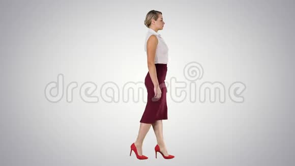 漂亮的年轻商务女性穿着正式的服装走在渐变的背景上视频的预览图
