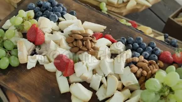 大什锦天然和健康的有机奶酪切德尔古达帕米森和水果浆果和坚果为年轻的盛宴视频的预览图
