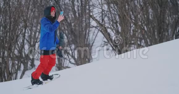 在滑雪坡滑雪时使用智能手机拍摄风景图片视频的预览图