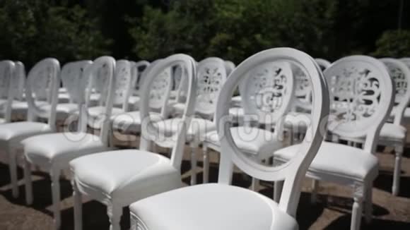 白色的椅子和婚礼装饰白色和红色的鲜花仪式花卉靠近大海视频的预览图