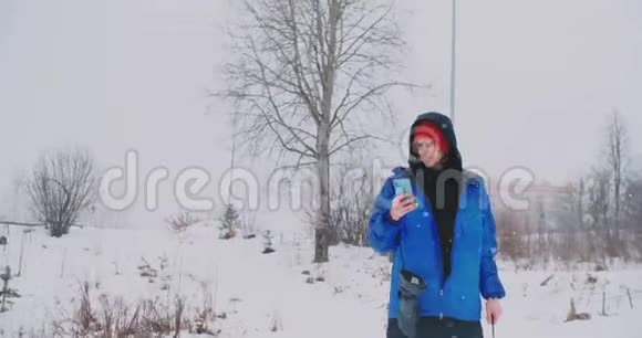 滑雪者在滑雪坡上驾驶时使用智能手机的慢速射击视频的预览图