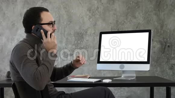 建筑师在电脑屏幕上打电话讨论项目白色显示器视频的预览图