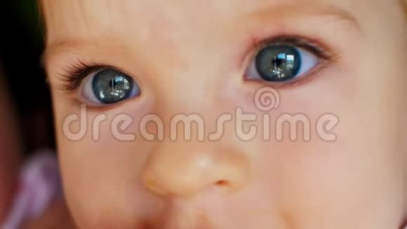 特写可爱微笑的小宝贝女孩的肖像小宝宝的情绪可爱的小女孩美丽的眼睛视频的预览图