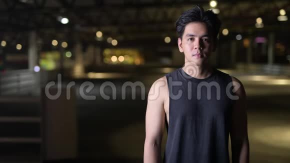 年轻快乐英俊的亚洲男人的肖像夜晚双臂交叉在户外视频的预览图