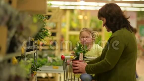 可爱的小女孩坐在车里帮助奶奶在超市购物视频的预览图
