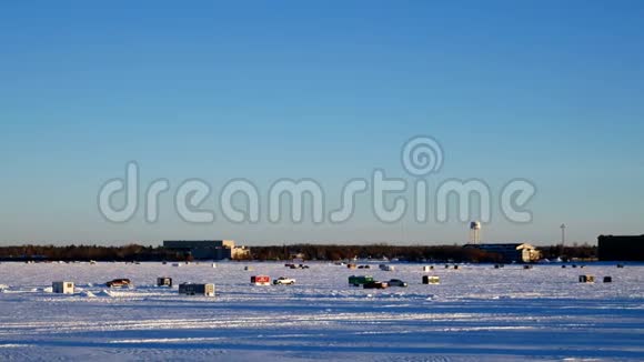 12月底的一个下午皮卡车驶过明尼苏达州冰湖贝米吉的冬季渔场视频的预览图