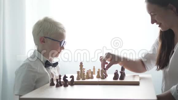 妈妈和儿子在房间的桌子旁下棋视频的预览图