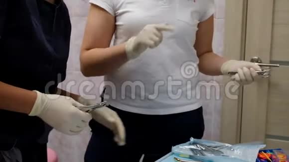 牙医戴着橡胶白手套手里拿着牙科器械向助手解释手的动作视频的预览图