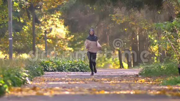 戴头巾的穆斯林妇女去秋日公园慢跑视频的预览图