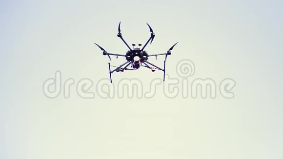 四架直升机无人机在晴朗的蓝天中盘旋降落在地面上视频和照片拍摄的概念剪辑黑色视频的预览图