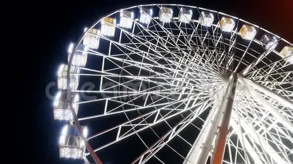 游乐园中的4K旋转照明摩天轮抗夜空视频视频的预览图