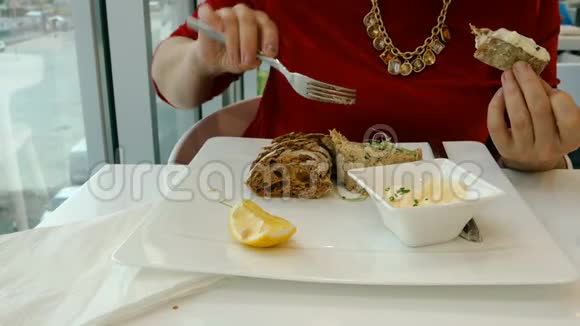 女人吃肉或鱼叉子面包和黄油视频的预览图